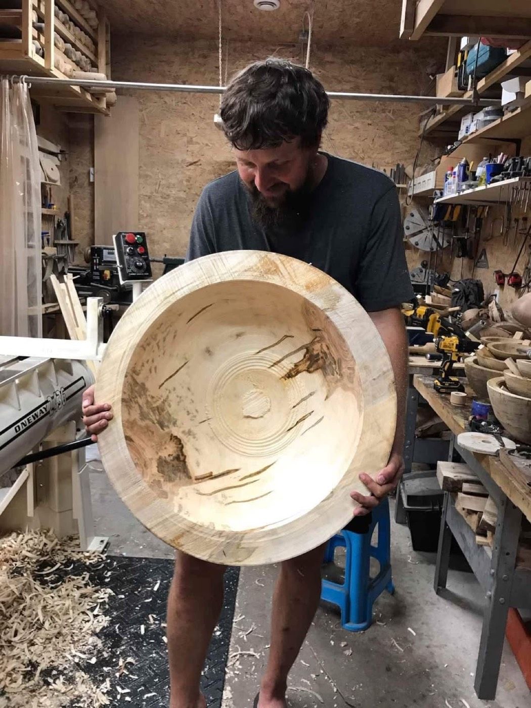 Colin holding a large finished bowl in his workshop